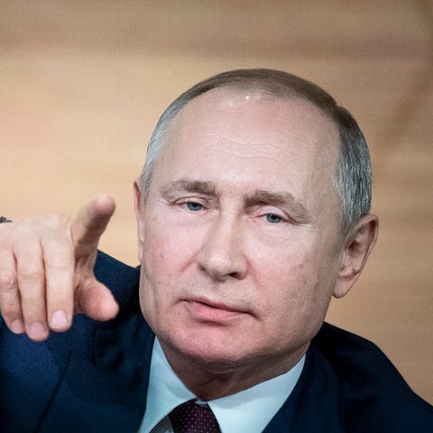 Russian President Vladimir Putin gestures during h