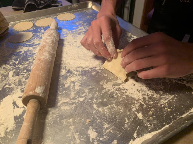 My son Jonah Taylor works to seal a pierogi after filling it.