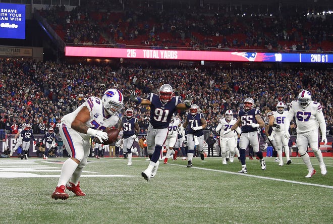 Buffalo Bills offensive tackle Dion Dawkins (73) catches a touchdown pass as New England Patriots defensive end Deatrich Wise (91) defends during the second quarter at Gillette Stadium.