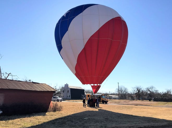 A hot air balloon landed in a small lot between South First and Second streets Sunday morning. It wasn't an emergency but to change personnel. Its chase bus is parked on the street. The balloon quickly rose back into the sky and headed north across Abilene.