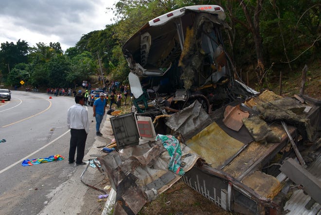 The wreckage of a passenger bus that crashed with a trailer truck lays on the side of the highway in Gualan, Guatemala, Saturday, Dec. 21, 2019