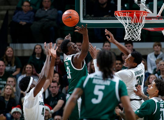 Eastern Michigan's Boubacar Toure, center, and Michigan State's Gabe Brown, left, and Marcus Bingham Jr. (30) vie for a rebound.