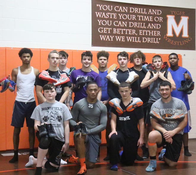 2015 Mansfield Senior grad and current assistant wrestling coach Jesse Palser, (front-right) shown here with the 2019-20 Tygers wrestling team, is on a mission to open a shoe bank allowing Mansfield youngsters who cannot afford wrestling shoes the opportunity to borrow a pair in order to compete.