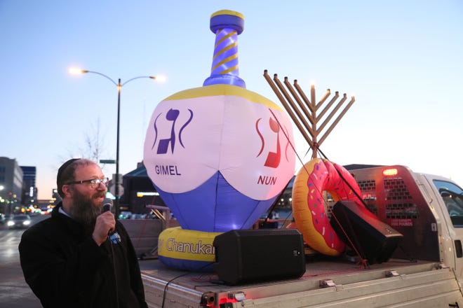 Rabbi Moshe Rapoport of the Peltz Center for Jewish Life in Mequon speaks at a parade to celebrate Hanukkah.