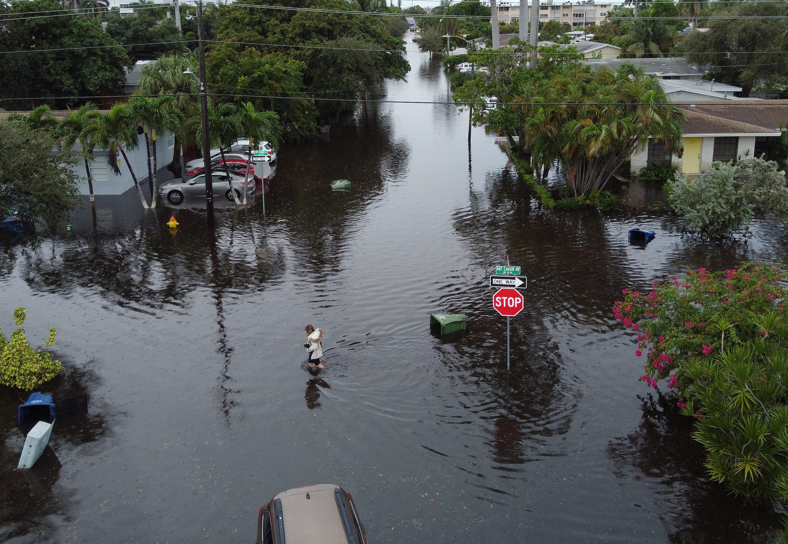 An aerial view from a drone shows a woman crossing a street inundated with floodwater on Dec. 23, 2019, in Hallandale, Fla. Hallandale is in Broward County, which has the highest of any county in the country.