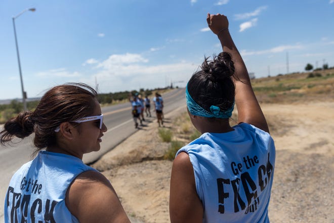 Andreanne Catt, left, and Lauren Howland prepare to join a group of runners protesting oil and gas drilling,  Monday, June 26, 2017 in Farmington.