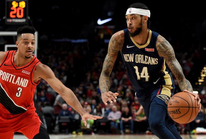 New Orleans Pelicans forward Brandon Ingram, right, drives to the basket on Portland Trail Blazers guard CJ McCollum, left, during the first half of an NBA basketball game in Portland, Ore., Monday, Dec. 23, 2019.