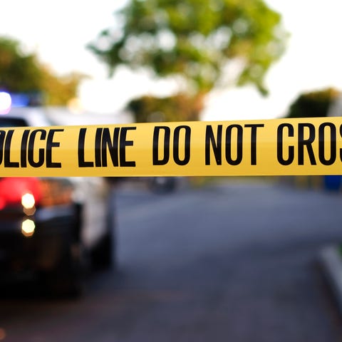 Generic police tape scene.         A blurred police ca