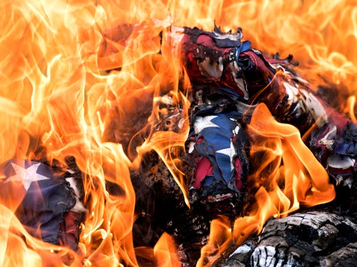 Flags burn in a pile during a flag retirement ceremony at Lyles Station Historic School and Museum in Princeton, Ind. Saturday, June 15, 2019. 54 flags where retired. 