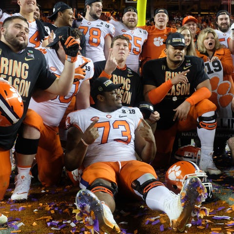 Clemson players pose on the field after defeating 