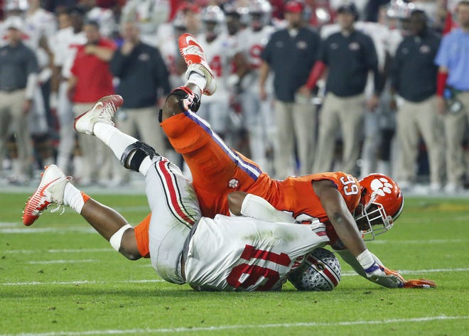 Ohio State Buckeyes quarterback J.T. Barrett (16) is knocked to the ground by Clemson Tigers defensive end Clelin Ferrell (99) during the second quarter of the College Football Playoff semifinal game in the PlayStation Fiesta Bowl on Dec. 31, 2016 at University of Phoenix Stadium in Glendale, Arizona.