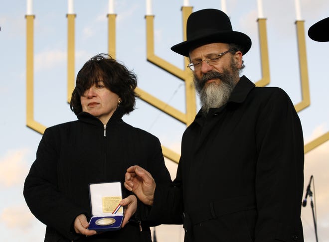 Rabbi Nachman and Frieda Holtzberg receive a medal during the lighting ceremony of the National Hanukkah Menorah, at the Ellipse in Washington Sunday Dec. 21, 2008, marking the beginning of the celebration of the Hanukkah.