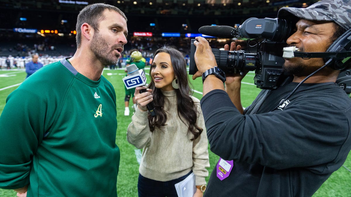 Carley McCord, middle, interviews Acadiana High School football coach Scott McCullough after the Louisiana  Division 5A championship game Saturday, Dec. 14, 2019.