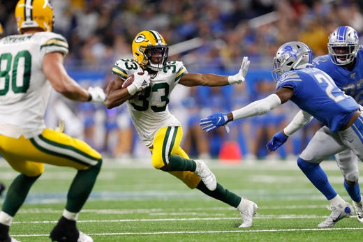 Green Bay Packers running back Aaron Jones (33) prepares to stiff arm Detroit Lions free safety Tracy Walker (21) during the fourth quarter at Ford Field.