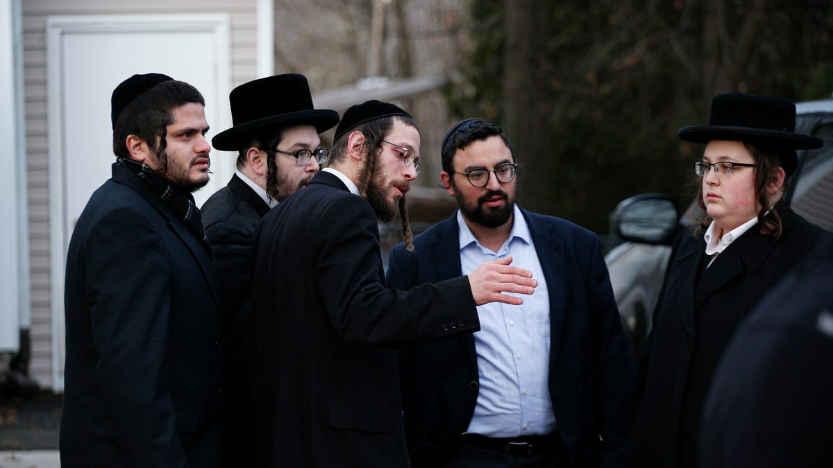 Members of the Jewish community gather outside the home of rabbi Chaim Rottenbergin Monsey, in New York on December 29, 2019 after a machete attack that took place earlier outside the rabbi's home during the Jewish festival of Hanukkah in Monsey, New York. - An intruder stabbed and wounded five people at a rabbi's house in New York during a gathering to celebrate the Jewish festival of Hanukkah late on December 28, 2019, officials and media reports said. Local police   departments, speaking to AFP, declined to give the number of people injured, but a suspect has been taken into custody and a vehicle safeguarded, an NYPD spokesman said. (Photo by Kena Betancur / AFP) (Photo by KENA BETANCUR/AFP via Getty Images) ORIG FILE ID: AFP_1NC7FS