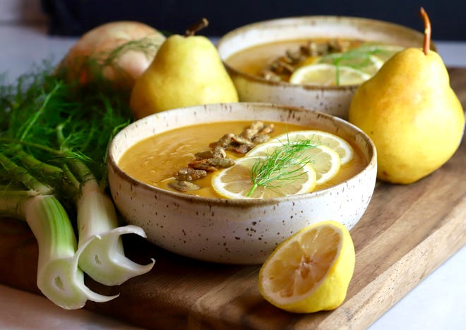 Butternut Squash and Pear Soup with Fennel is topped with lemon slices and pumpkin seeds.
