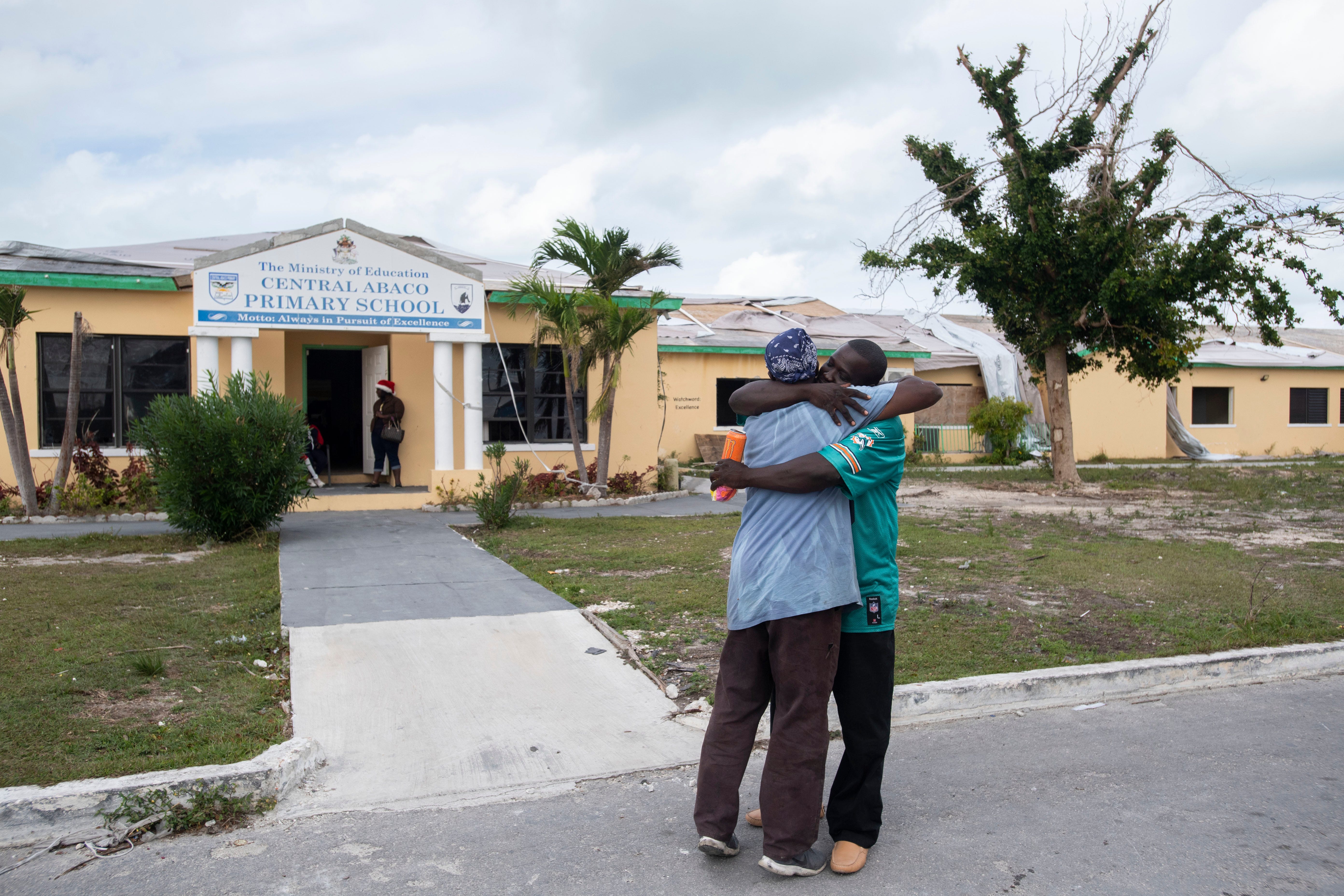 Paul Mills (left) and Exalise Gue see each other for the first time following the September 1 impact of Hurricane Dorian on Saturday, Dec. 21, 2019, at the Central Abaco Primary School in Marsh Harbour, Bahamas. “On the 29th of August, we were out eating chicken wings. On September 1st, it was a whole new world. We were just looking for who was alive,” Mills said. The damaged school is no longer operating as an education center, but as a makeshift food distribution center. 