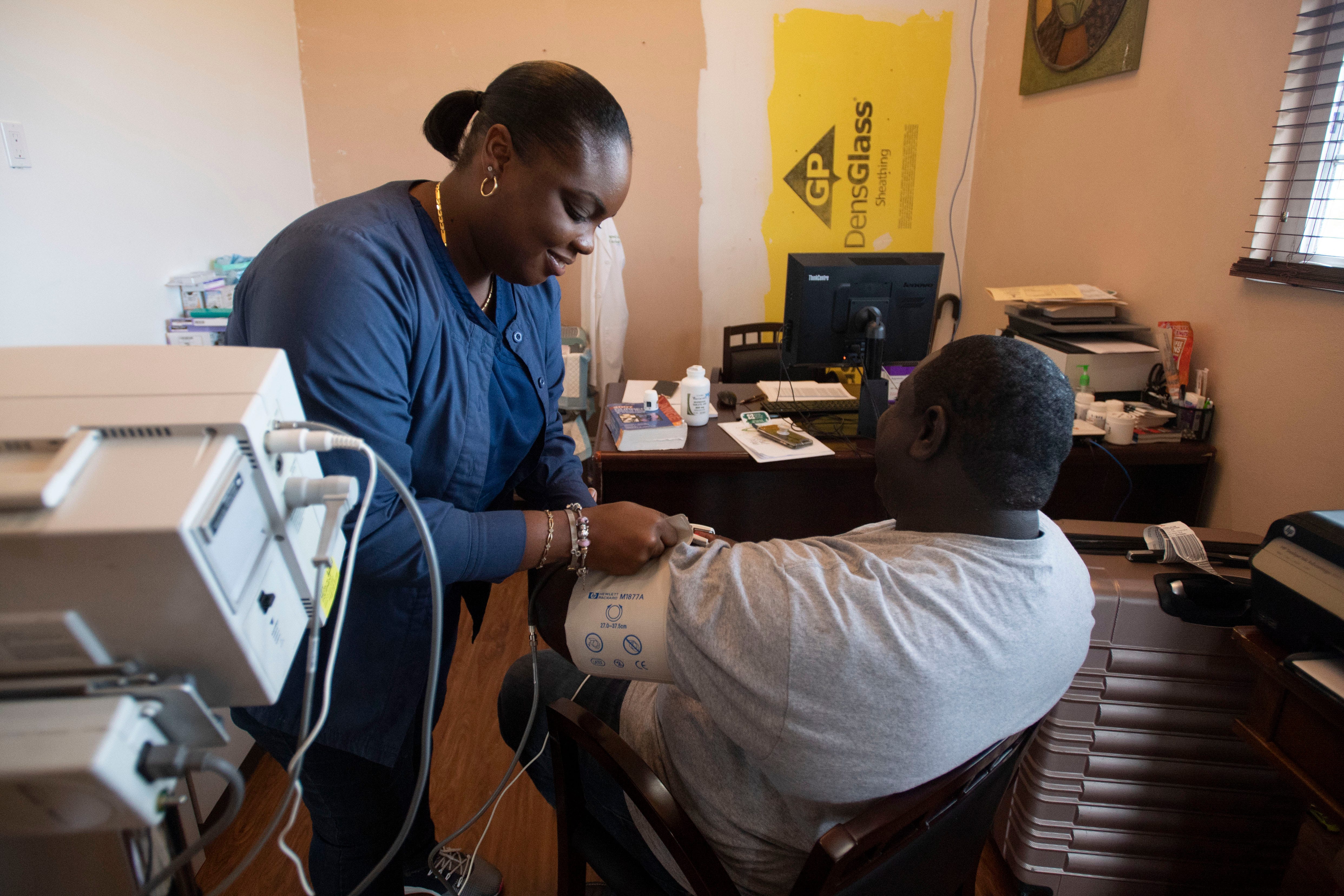 Integrated Medical Centre nurse Chenara Edwards conducts a checkup on patient Ryan Forbes on Saturday, Dec. 21, 2019, at a funeral home turned medical clinic in Marsh Harbour, Bahamas.