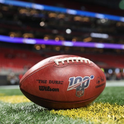 The NFL 100 logo is shown on a Wilson football bef