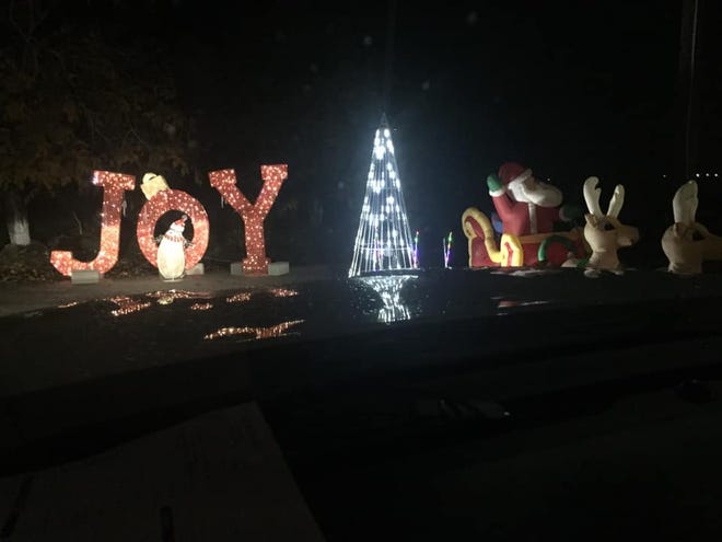 Cars drive down the Kupers Christmas Lane lined with lights and decorations in December 2019.