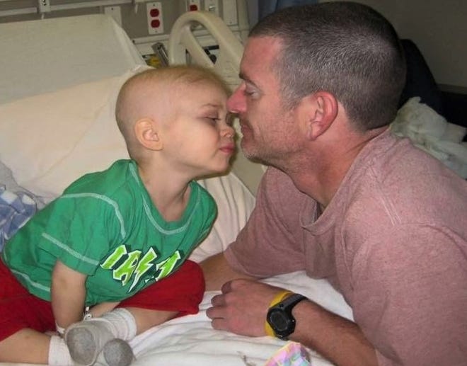 Finn is shown with his father, John Hall, during the nearly 18-month period about ten years ago in which the boy battled cancer through chemotherapy, radiation and immunotherapy.