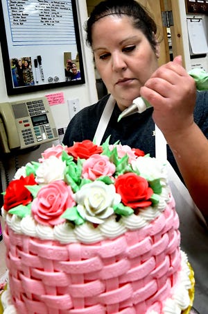Brown's Orchards & Farm Market cake decorator Jen Rutters uses a piping bag to decorate a Valentine basket weave cake in the market's bakery Friday, Jan. 3, 2020. Construction is underway an event venue at the farm market. A spokesperson said event organizers have the option of using the market's bakery and catering services during events. Bill Kalina photo