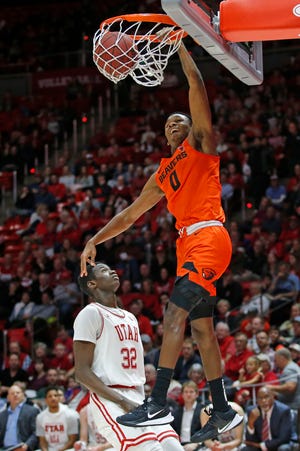 Oregon State guard Gianni Hunt (0) dunks on Utah center Lahat Thioune (32) in the first half during an NCAA college basketball game Thursday, Jan. 2, 2020, in Salt Lake City.