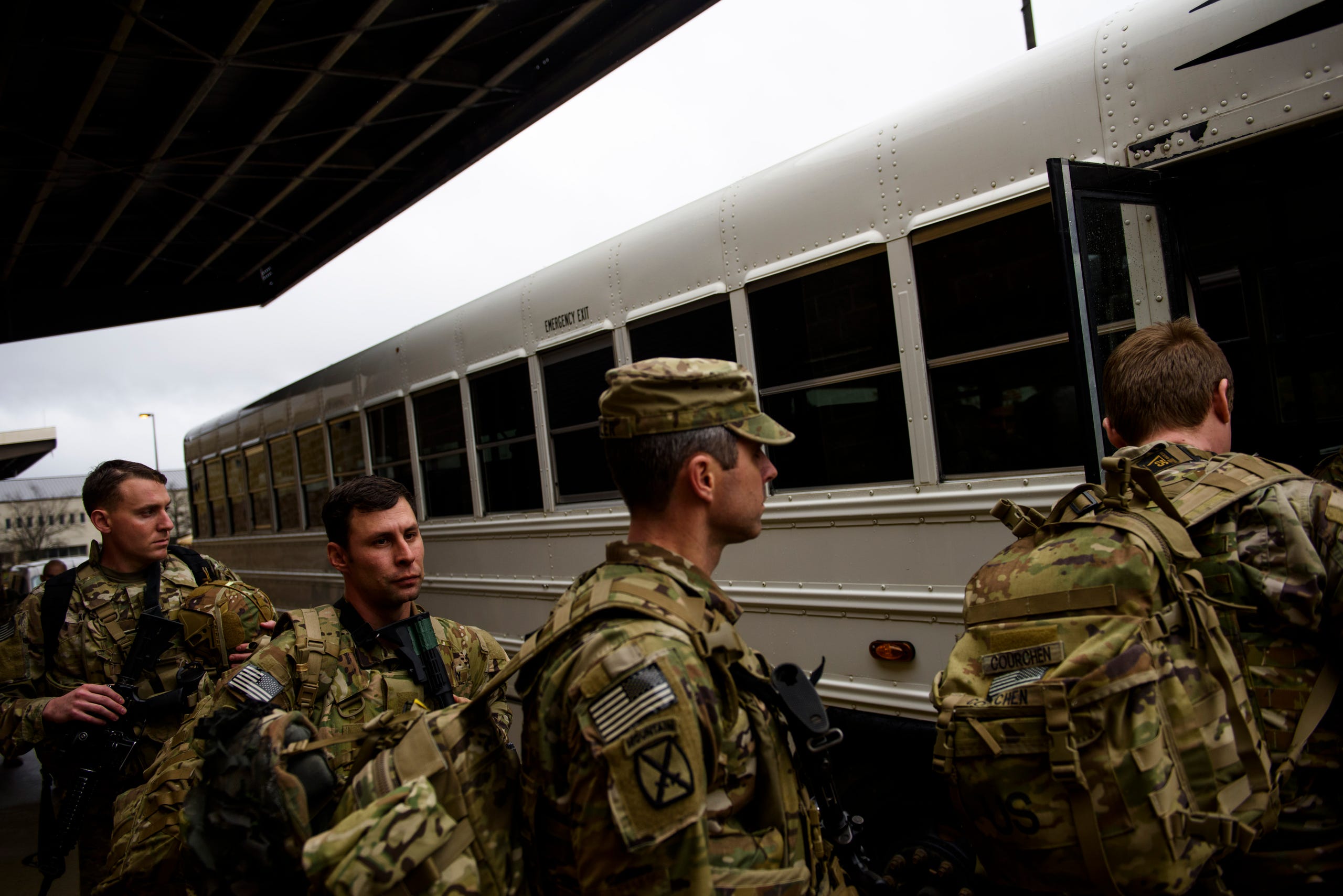 Soldiers with the 82nds Airborne Division load a bus to be transported to a military transport aircraft at Fort Bragg.