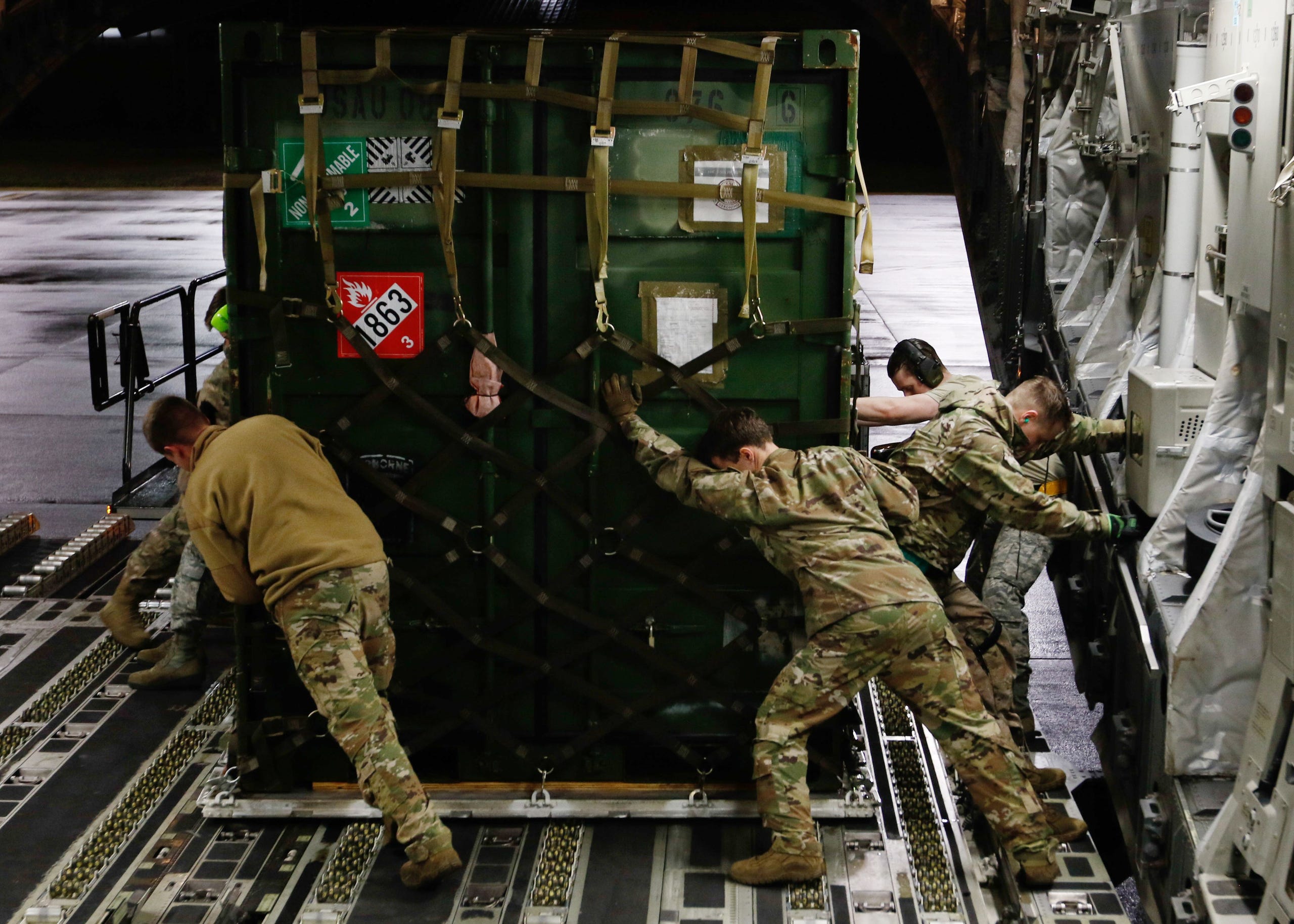  US Air Force personnel load 82nd Airborne Division equipment onto a C-17 Globemaster aircraft bound for the US Central Command area of operations