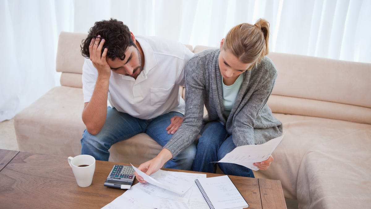 Depressed couple doing their accounting in their living room