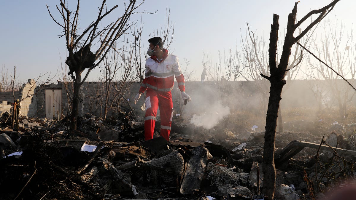 A rescue worker searches the scene where an Ukrainian plane crashed in Shahedshahr, southwest of the capital Tehran, Iran, Jan. 8, 2020. A Ukrainian airplane carrying 176 people crashed on Wednesday shortly after takeoff from Tehran's main airport, killing all onboard.