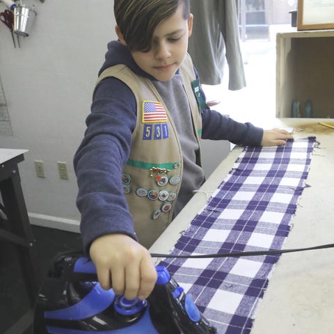 Quest Club member Aaron Jimenez irons fabric befor