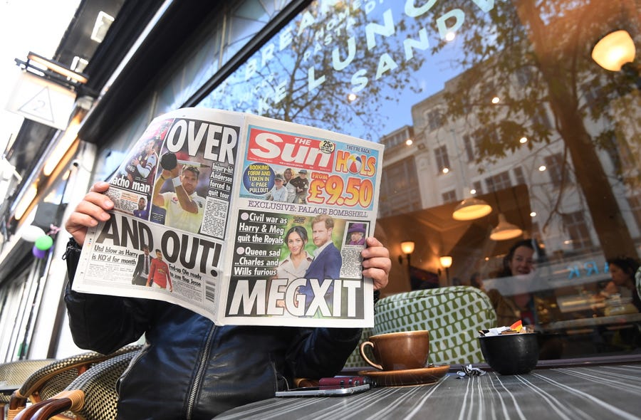 A man poses with The Sun newspaper's leading story of the Britain's Duke and Duchess of Sussex in London,  Jan. 9, 2020. Prince Harry and Meghan have announced in a statement that they will step back as 'senior' royal family members and work to become financially independent.