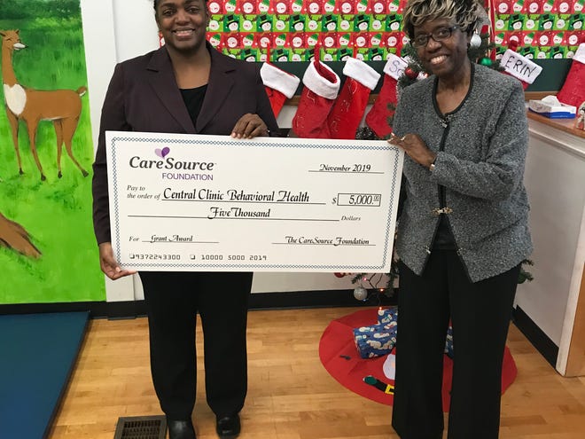 Vanessa R. Brown, LPCC, LICDC, CTP-C, Clinical and Program Director of the Family Healing Center, Central Clinic Behavioral Health (left) receives a check from Lera Battle (right), the CareSource Foundation.