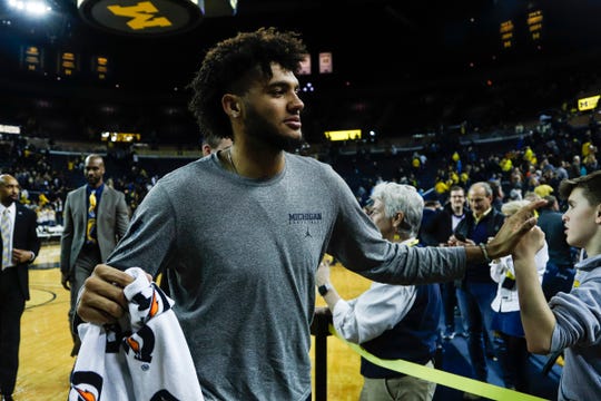 Michigan forward Isaiah Livers high fives fans as he walks back towards locker room after the Wolverines won 84-78 over Purdue at Crisler Center in Ann Arbor, Thursday, Jan. 9, 2020.