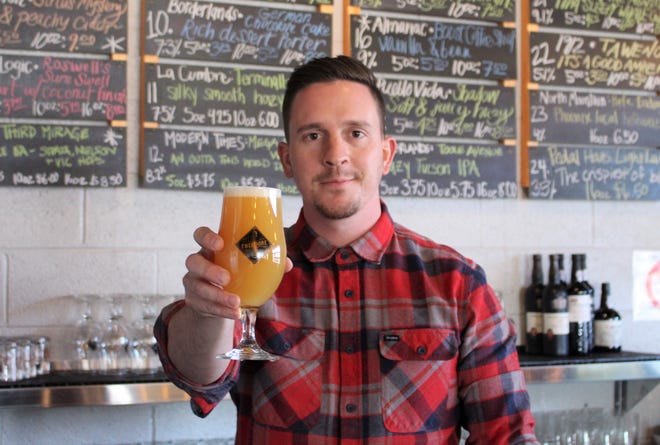 Justin Evans pours an IPA at The Theodore, his newest beer bar and bottle shop on Roosevelt Row. He also owns The Wandering Tortoise, The Sleepy Whale and The Golden Pineapple, soon to open in Tempe.