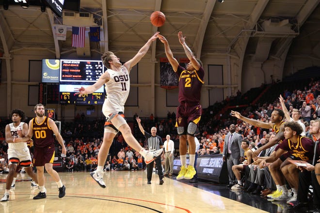 Arizona State's Rob Edwards, center right, shoots a 3-pointer over Oregon State's Zach Reichle during the second half of an NCAA college basketball game in Corvallis, Ore., Thursday, Jan. 9, 2020.