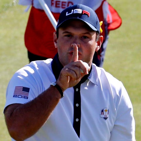 Patrick Reed puts his finger to his lipes to ask f