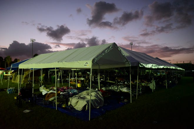 Tents and cots are set up for people whose homes are either destroyed or unsafe to enter after an 6.4 magnitude earthquake, at a baseball stadium amid aftershocks and no electricity in Guayanilla, Puerto Rico, at sunrise Friday, Jan. 10, 2020.