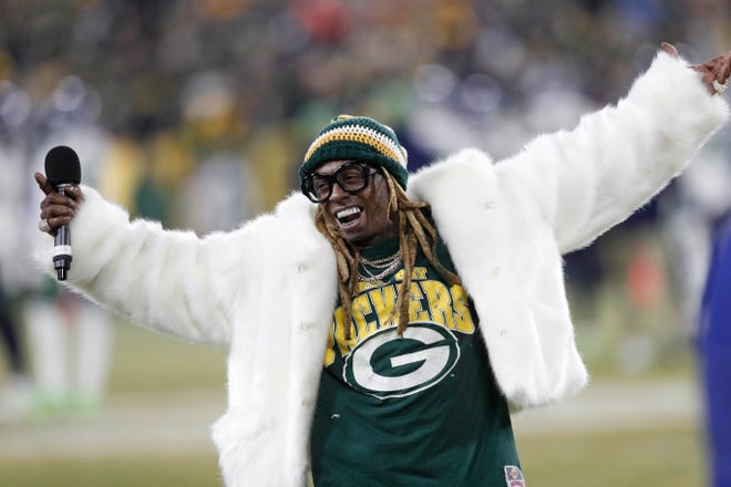 Lil Wayne addresses the crowd at Lambeau Field in the second half of a NFC divisional round playoff game between the Green Bay Packers and Seattle Seahawks in January 2020.