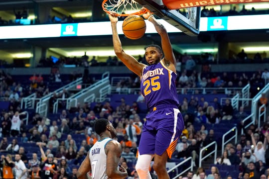 Phoenix Suns forward Mikal Bridges dunks over Charlotte Hornets guard Dwayne Bacon (7) during the second half of an NBA basketball game Sunday, Jan. 12, 2020, in Phoenix. Phoenix won 100-92. (AP Photo/Rick Scuteri)