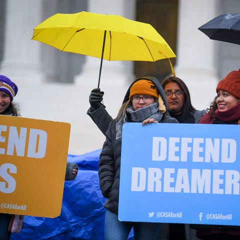 Demonstrators stand in the cold and rain outside t