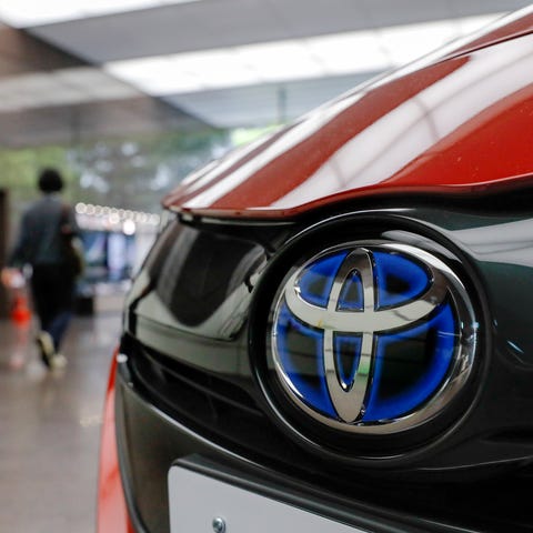 Office workers walk past Toyota Motor's plugin hyb