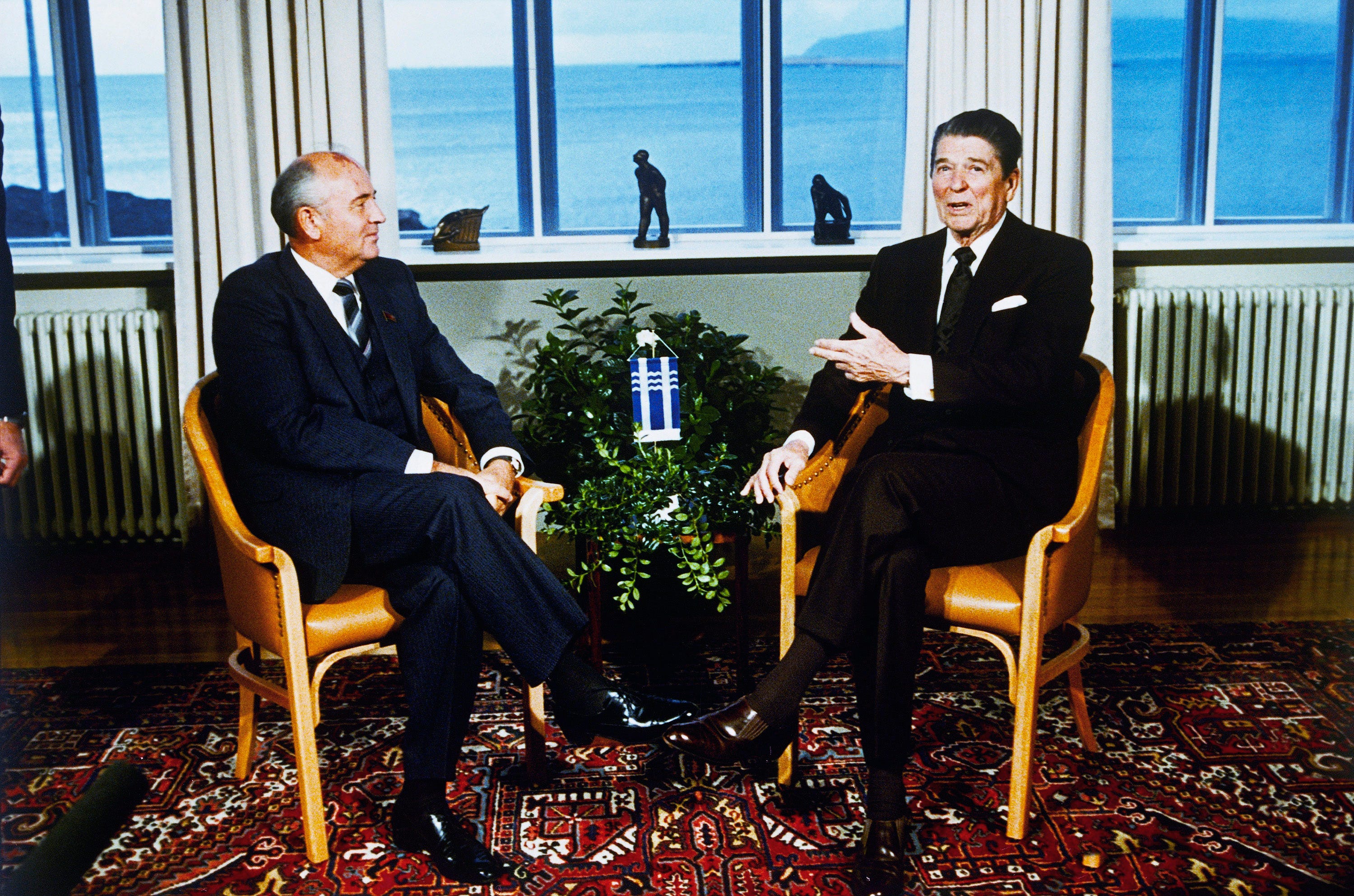 Soviet Leader Mikhail Gorbachev, left, and U.S. Pres. Ronald Reagan, right, sit inside the Hofdi at the start of a series of talks, Saturday, Oct. 11, 1986, Reykjavik, Iceland. The other men are unidentified. 