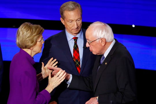 Democratic presidential candidate Sen. Elizabeth Warren, D-Mass., left and Sen. Bernie Sanders, I-Vt., talk Tuesday, Jan. 14, 2020, after a Democratic presidential primary debate hosted by CNN and the Des Moines Register in Des Moines, Iowa. Candidate businessman Tom Steyer looks on.