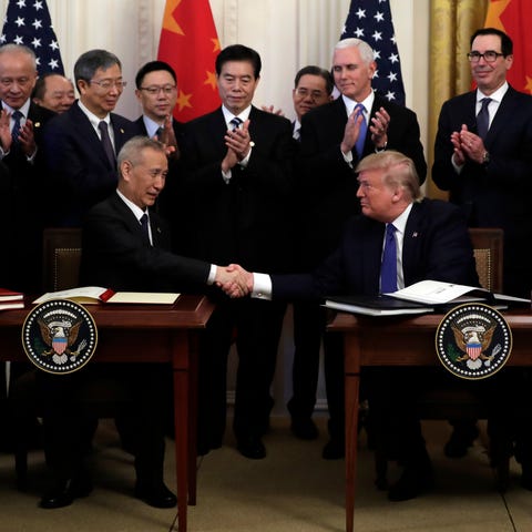 President Donald Trump shakes hands with Chinese V