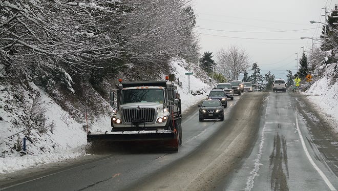 A snow plow scrapes the shoulder of Viking Avenue in Poulsbo on Wednesday, Jan. 15, 2020.