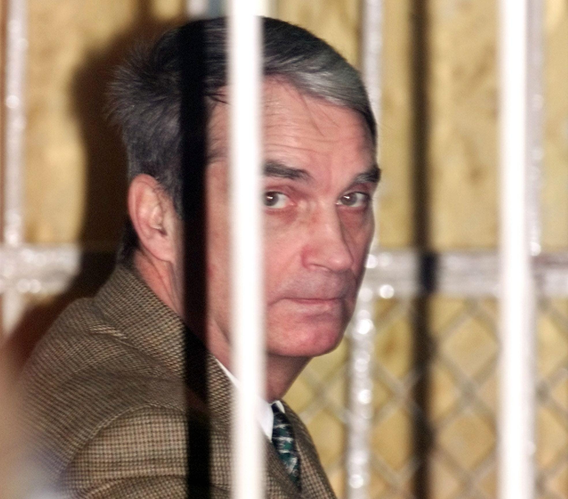 U.S. businessman Edmond Pope sits behind bars during a closed-door spy trial against him in Moscow, December 1, 2000. U.S. businessman Edmond Pope's lawyer asked a Moscow judge to acquit his client of espionage charges, saying in closing statements that prosecutors had failed to prove Pope did anything illegal.