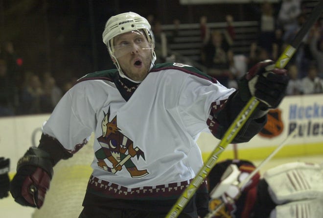 Coyotes defender Deron Quint celebrates after scoring a goal against Flames goalie Roman Turek during the 2nd period at America West Arena during the 2003 season. Quint is set to become a police officer in Phoenix later this month.