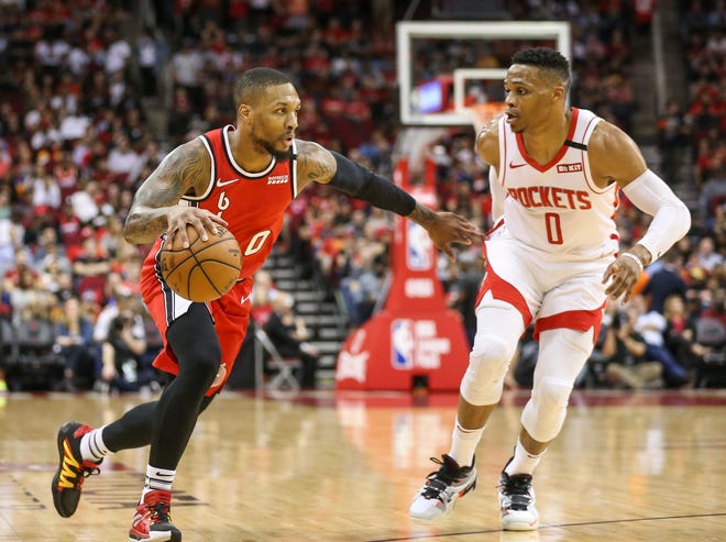 Portland Trail Blazers guard Damian Lillard (left) dribbles the ball against Houston Rockets guard Russell Westbrook (right) during the first quarter at Toyota Center.